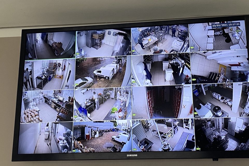 Monitor de CFTV exibindo mosaico com várias câmeras internas.