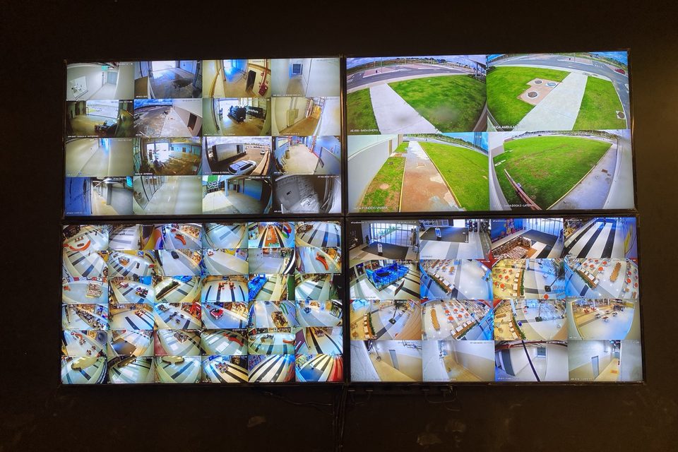 Videowall com quatro monitores exibindo imagens de várias câmeras.